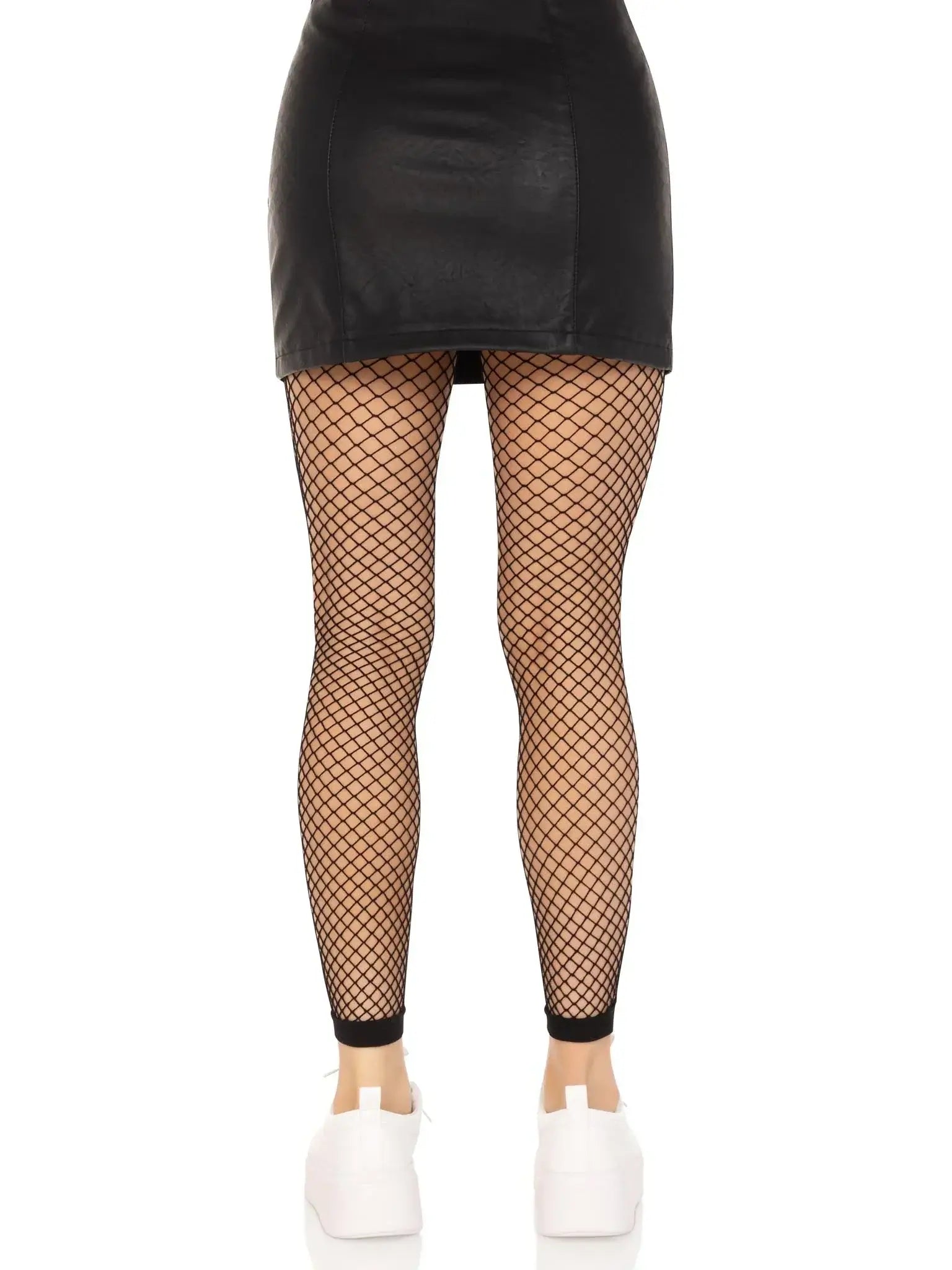 Classic Delilah Fishnet Footless Tights by Leg Avenue, styled with a black skirt and white shoes, showcasing breathable, wide fishnet design.