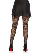 Woman wearing black skirt and Wild Rose Net Tights with floral design and diamond pattern, paired with black high heels.